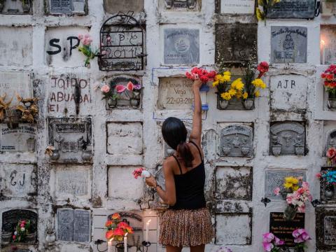Une jeune femme fleurit une tombe pendant la fête des morts de la semaine sainte Mompox, Colombie - 2018