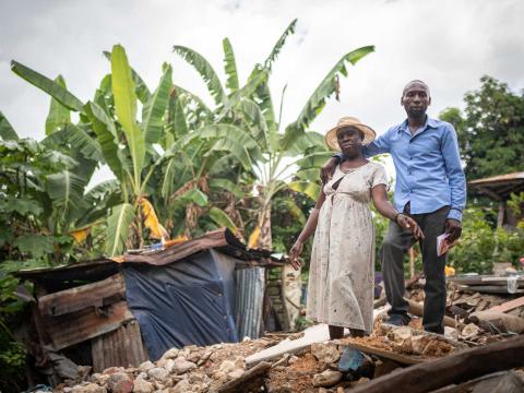 Une femme et son fils posent devant les décombres de leur maison intégralement détruite par le séisme du 14 août 2021 Camp Perrin, Haïti - 2021