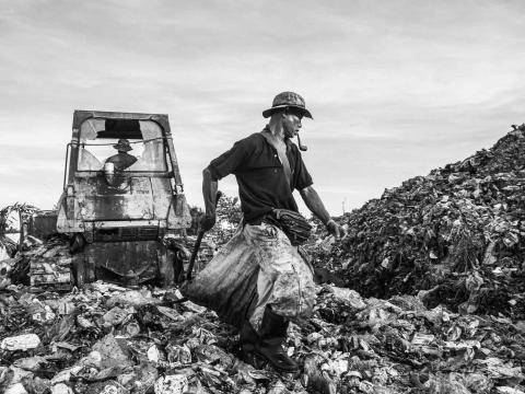 Un migrant birman fouille parmi des déchets dans la décharge ou il habite avec sa famille. Il gagne l''équivalent de 50€ par mois en revendant le métal et le verre qu'il trouve au milieu des immondices Mae Sot, Thaïlande - 2014