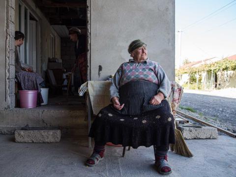 Nazo, 80 ans, est assise devant la maison qu'elle occupe dans un camp de déplacé. Elle a dû quitter son village suite à l'annexion de l'Ossétie du sud par la Russie. Gori, Géorgie - 2016