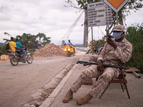 Un policier assure la circulation devant le pont de Jeremie, principale voie d’accès à la ville gravement endommagée par le séisme. Jeremie, Haïti. Septembre 2021