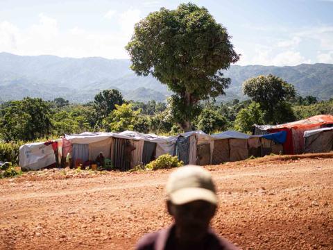 Un homme se tient devant les tentes d’un camps de réfugiés. Région de Pestel, Haïti. Septembre 2021.