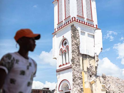 Un jeune homme marche devant l'église principale qui s'est partiellement effondrée durant le séisme. Les Cayes, Haïti - Septembre 2021