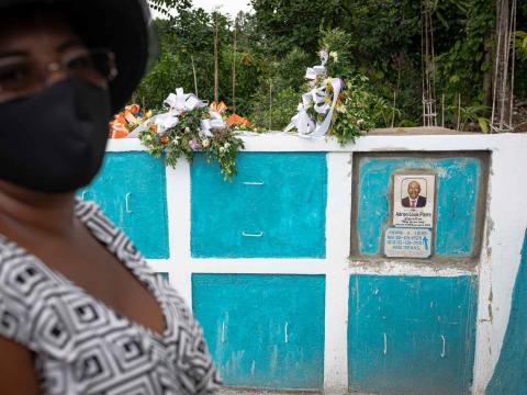 Une femme se tient à côté de la tombe de son père, décédé suite à ses blessures lors du séisme. Camp Perrin, Haïti. Septembre 2021.