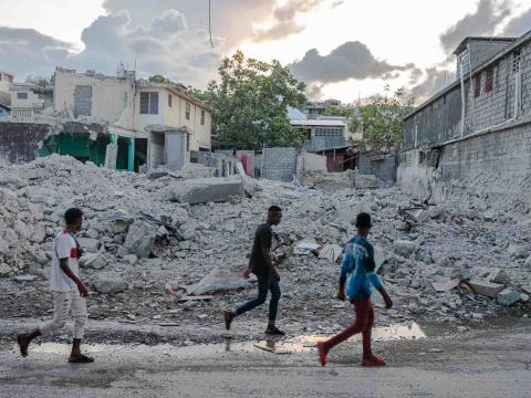 Des passants marchent devant les décombres d’un immeuble du centre historique. Jeremie, Haïti. Septembre 2021