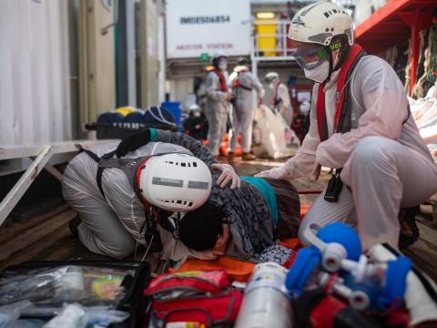 Les membres de l'équipe médicale prennent en charge une rescapée qui vient d’être secourue. Méditerranée Centrale. Mars 2021