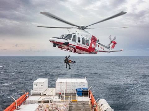 Une femme enceinte proche du terme est évacuée en brancard par un hélicoptère des gardes côtes italiens lors d'une évacuation sanitaire.