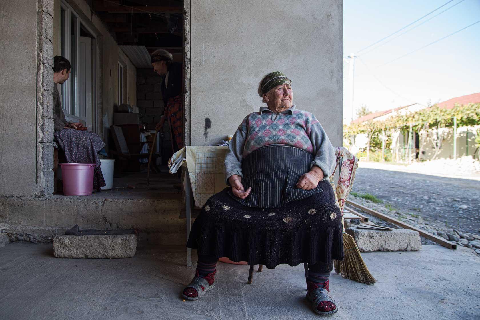 Nazo, 80 ans, est assise devant la maison qu'elle occupe dans un camp de déplacé. Elle a dû quitter son village suite à l'annexion de l'Ossétie du sud par la Russie. Gori, Géorgie - 2016
