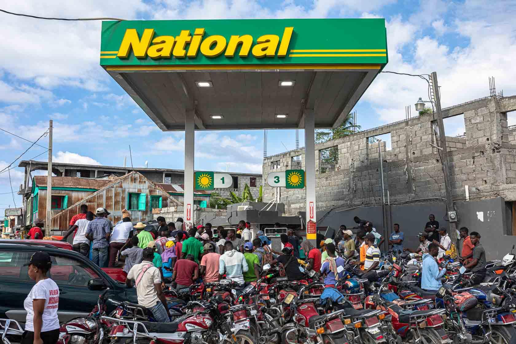 Des conducteurs de moto-taxi sont rassemblés devant une station essence qui vient d’être ravitaillée. Les pénuries sont régulières depuis le séisme et l’approvisionnement en essence est particulièrement touché. Jeremie, Haïti. Septembre 2021.