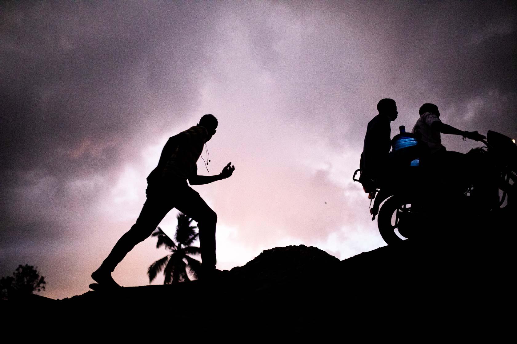 Des hommes passent à moto et à pieds sur le pont désormais interdit à la circulation des camions. Jeremie, Haïti. Septembre 2021