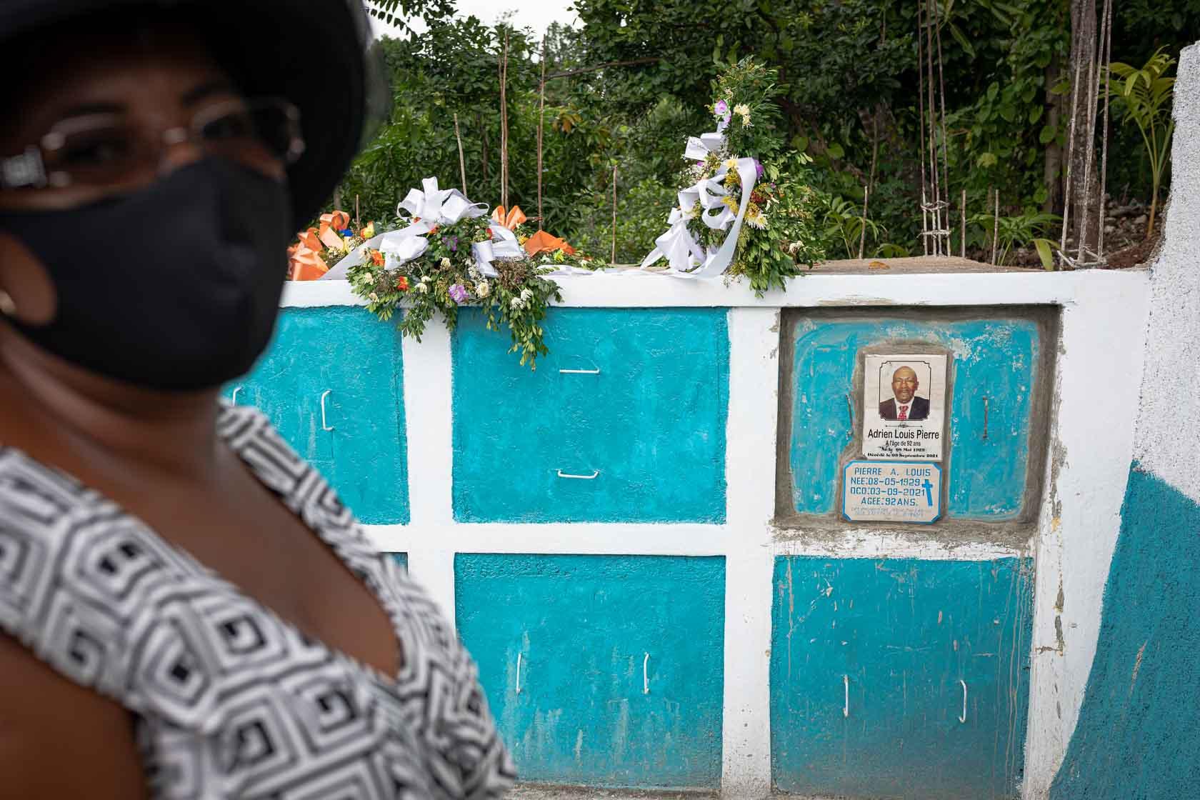 Une femme se tient à côté de la tombe de son père, décédé suite à ses blessures lors du séisme. Camp Perrin, Haïti. Septembre 2021.