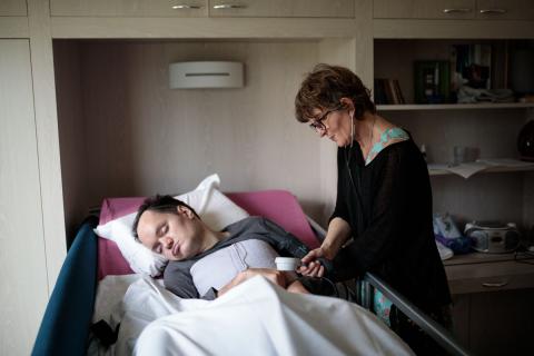 Une infirmière prend la température d'un homme alité dans un établissement Rezé, France - 2018