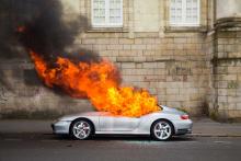 Une Porsche brûle devant la préfecture de Loire-Atlantique en marge d'une manifestation contre la "Loi Travail".  Nantes, France - 28 avril 2016