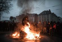 Un manifestant saute par dessus une poubelle enflammée durant un rassemblement des "gilets jaunes" Nantes, France - 2019