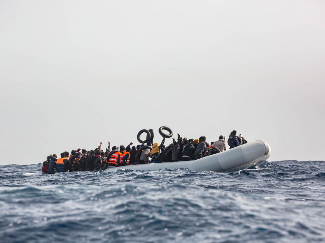 Un bateau pneumatique surchargé sur lequel se trouvent une centaine de migrants, hommes, femmes et enfants, fuyant la Libye.